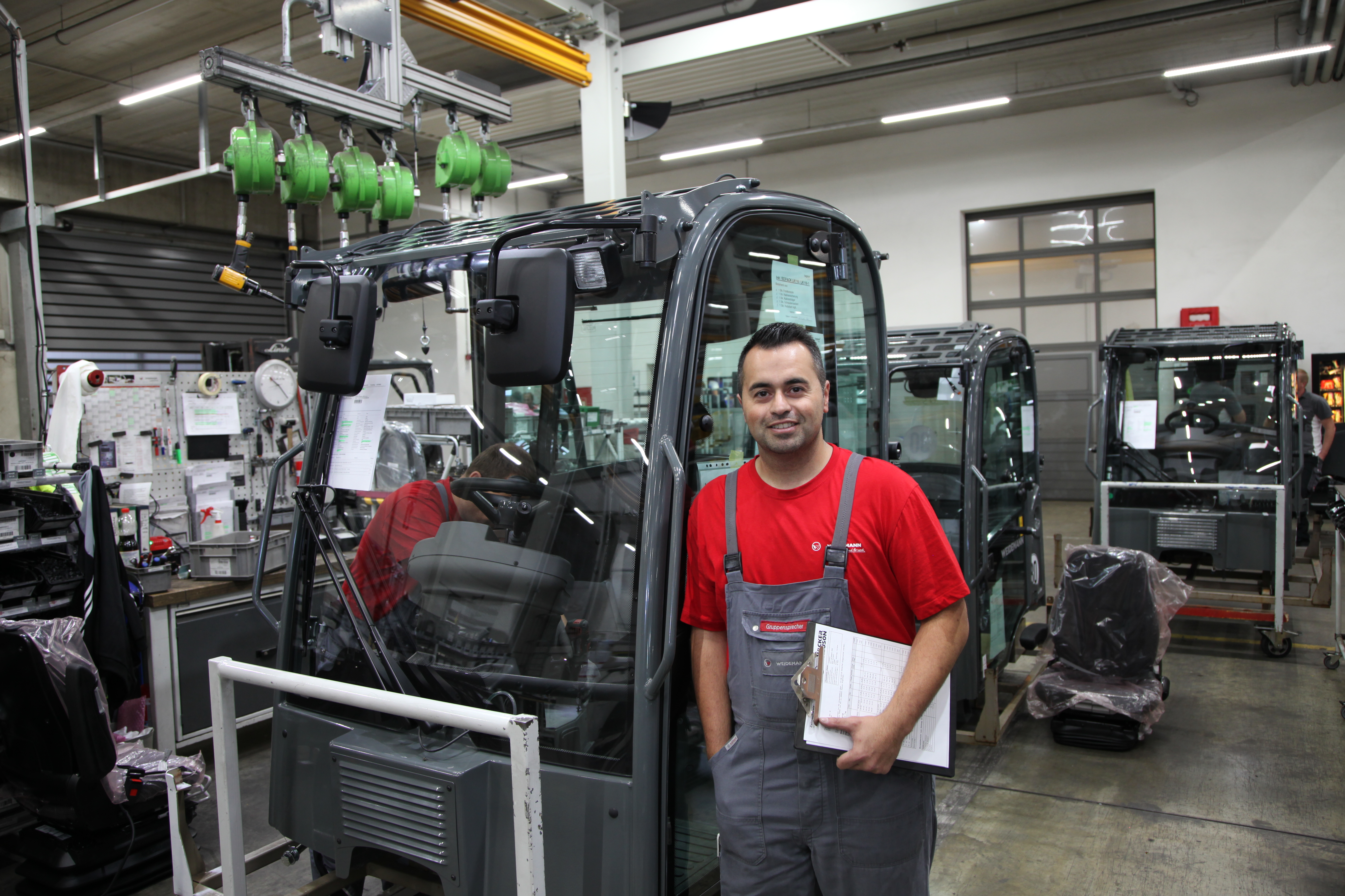 Un employé Weidemann se trouve à la production sur la cabine de la machine