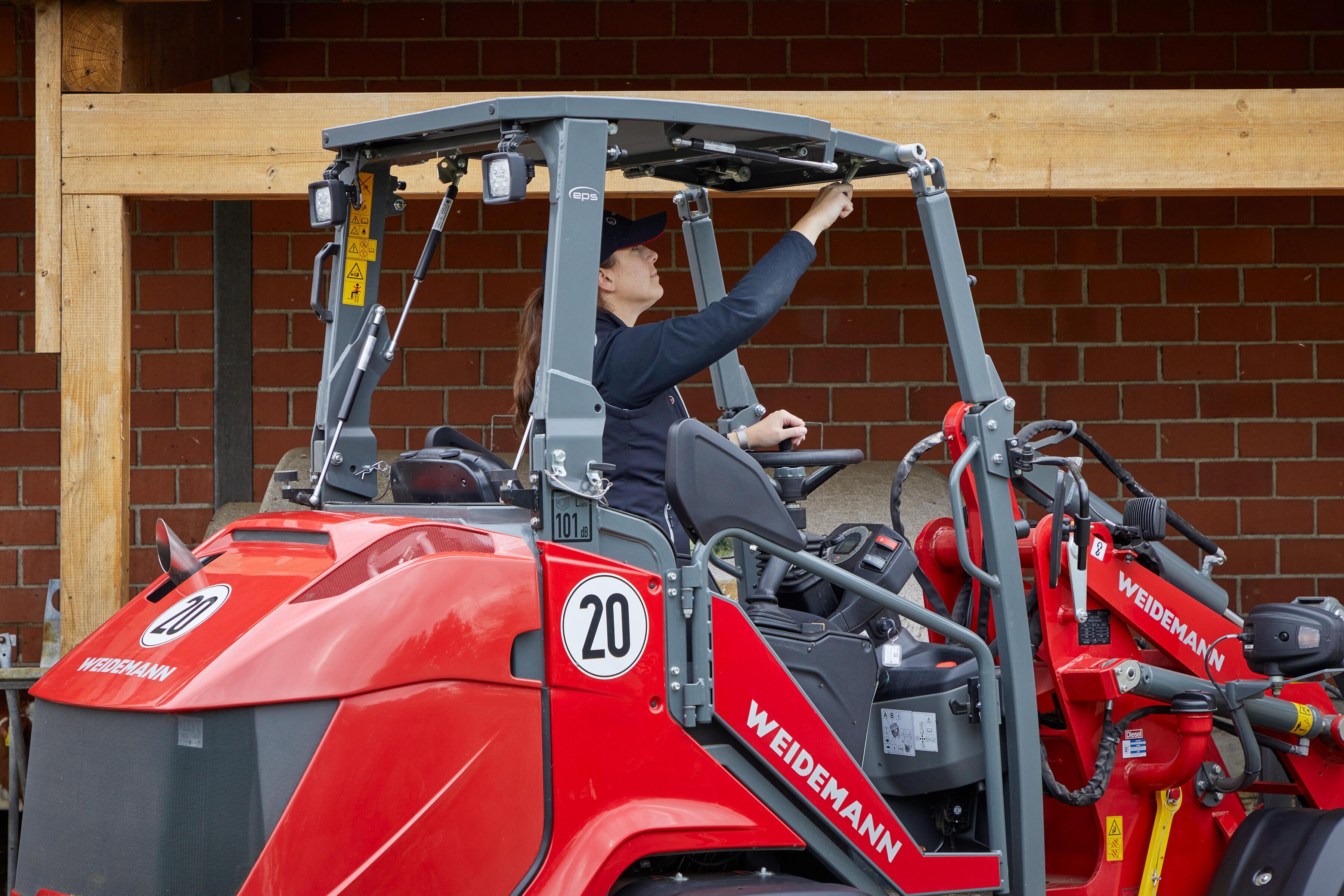 Weidemann Hoftrac 1390 - en kvinde klapper sikkerhedstaget ned