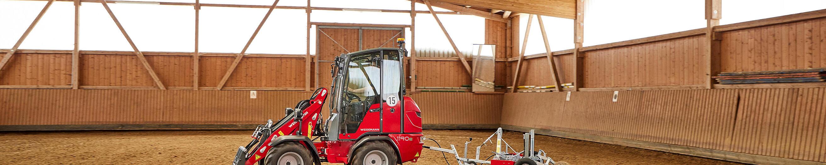 Hoftrac 1190e con cabina de Weidemann en acción con aplanador de picaderos y pistas