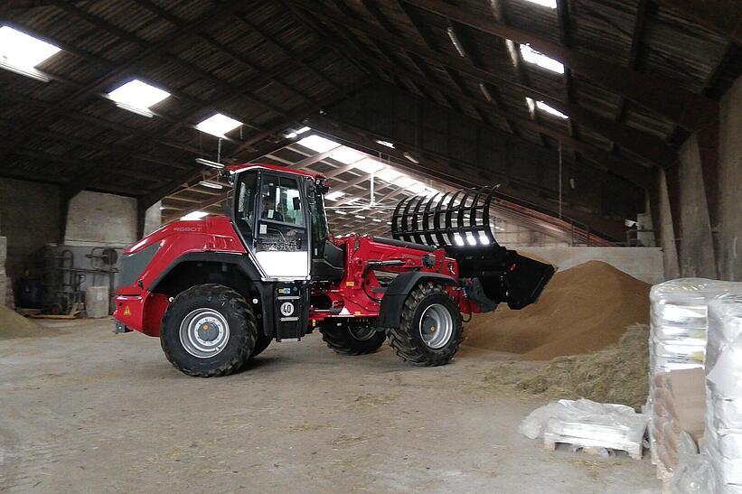Weidemann Teleskopradlader 9580T im Einsatz mit Greifschaufel in einer landwirtschaftlichen Halle