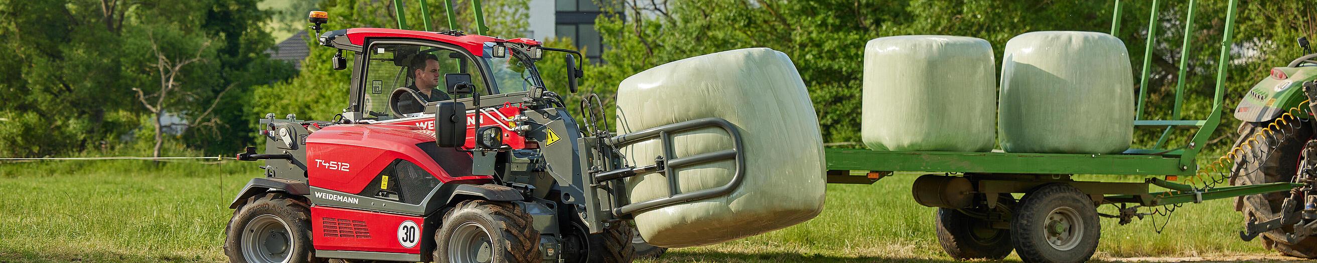 Cargadora telescópica T4512 de Weidemann en acción con pinza para balas