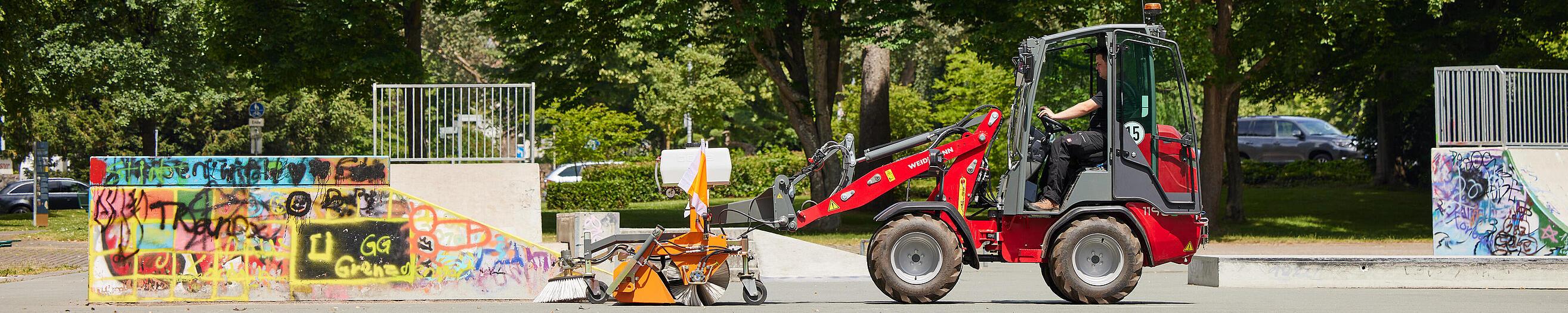 Weidemann Hoftrac 1190e Kabine im Stadtpark mit Kehrmaschine