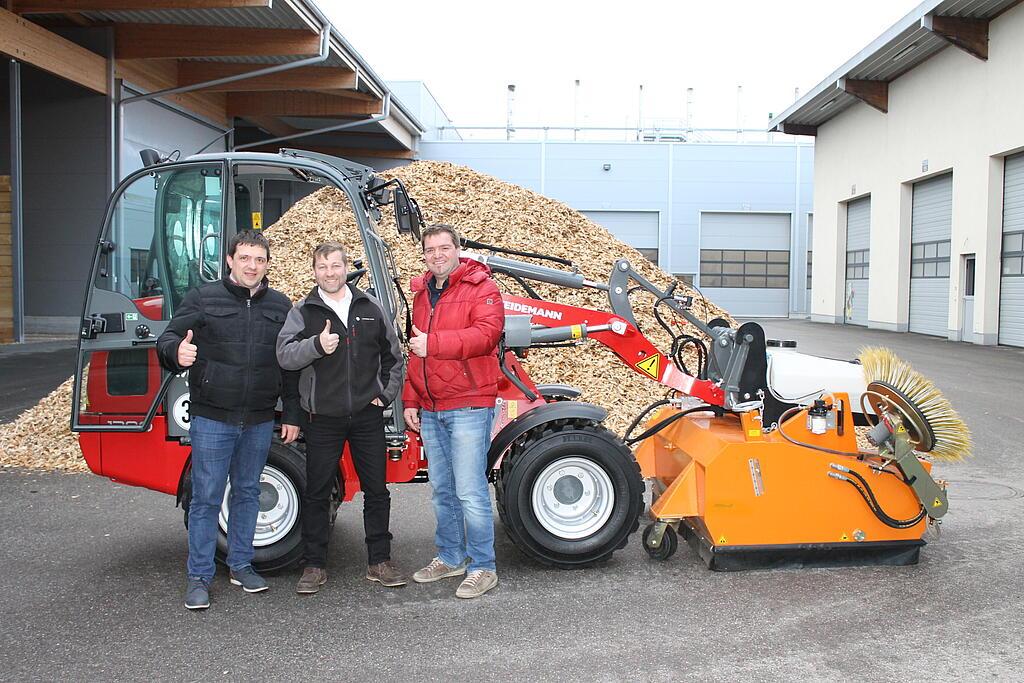 V.l.n.r.: Anton Hargassner jun. (Hargassner GmbH), Gebietsverkäufer Peter Grabner (Mauch Ges.m.b.H & Co.KG) und Markus Hargassner (Hargassner GmbH) bei der Übergabe des neuen 1280. Imagine de grup, persoane cu utilajul