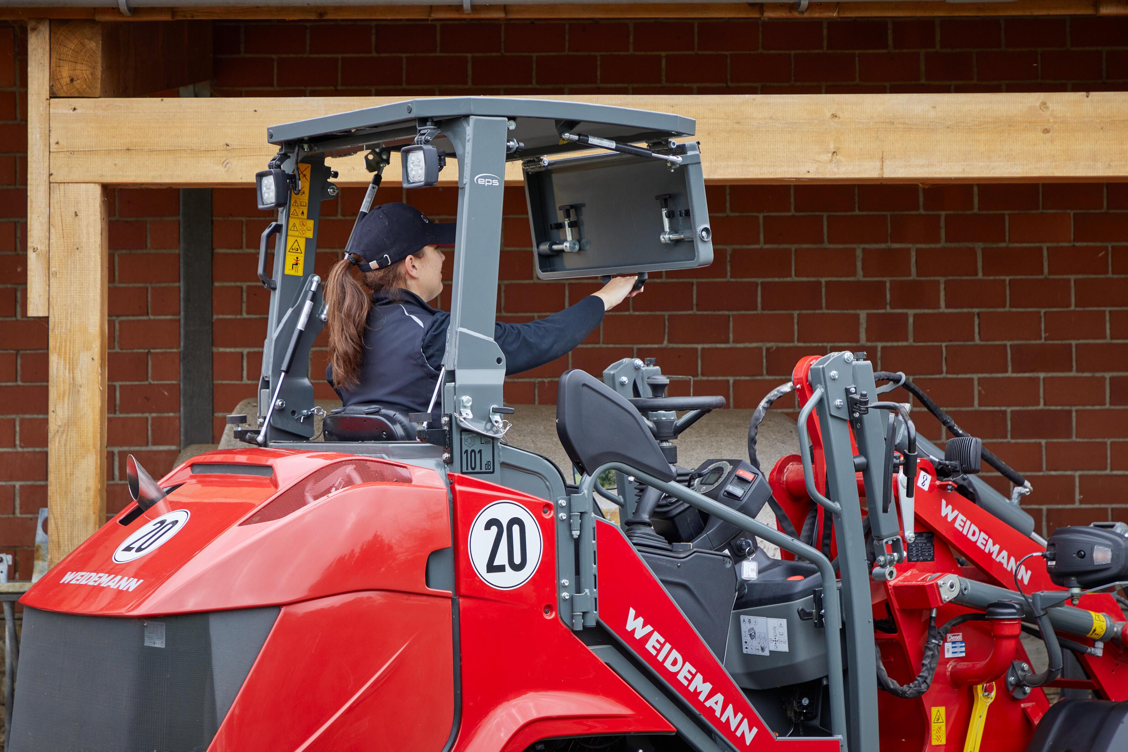 Weidemann Hoftrac 1390 - en kvinde klapper sikkerhedstaget ned