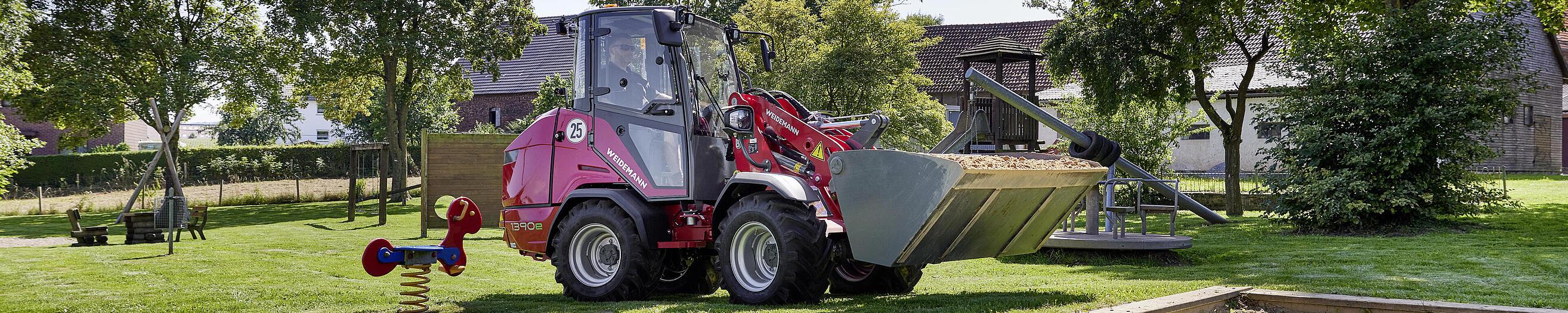 Weidemann Hoftrac 1390e mit Kabine auf einem Spielplatz