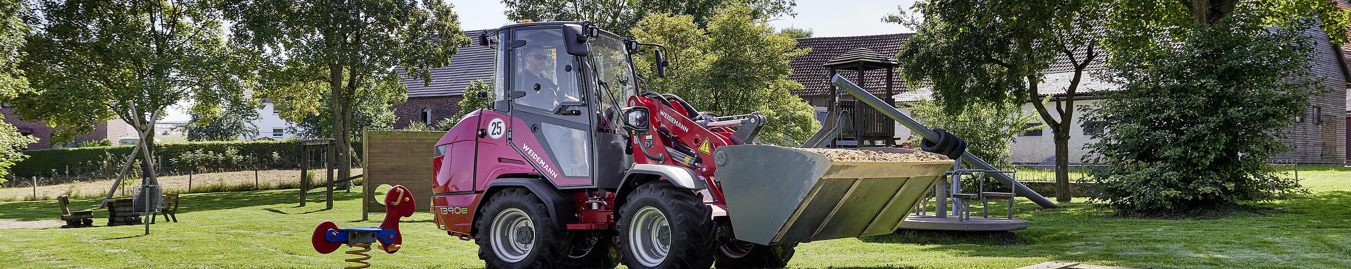 Weidemann Hoftrac 1390e mit Kabine auf einem Spielplatz