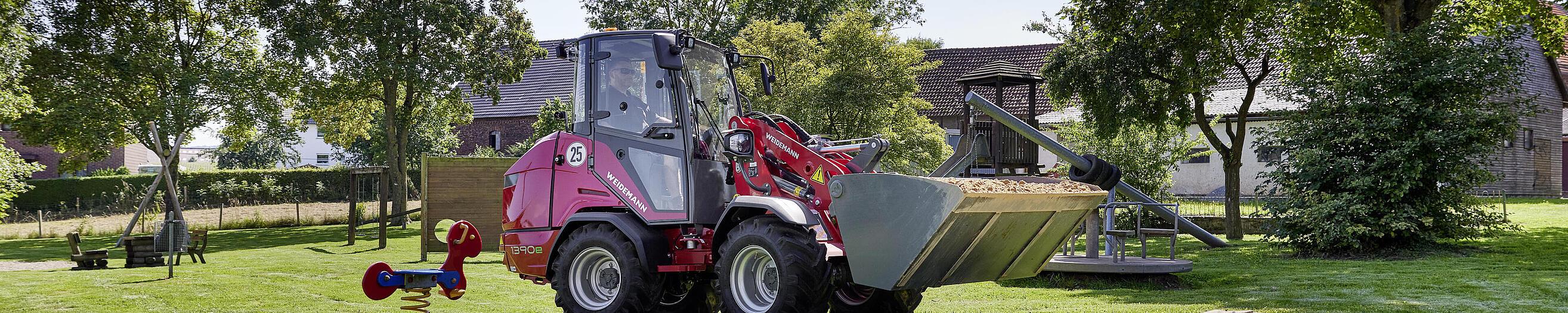 Weidemann Hoftrac 1390e mit Kabine auf einem Spielplatz