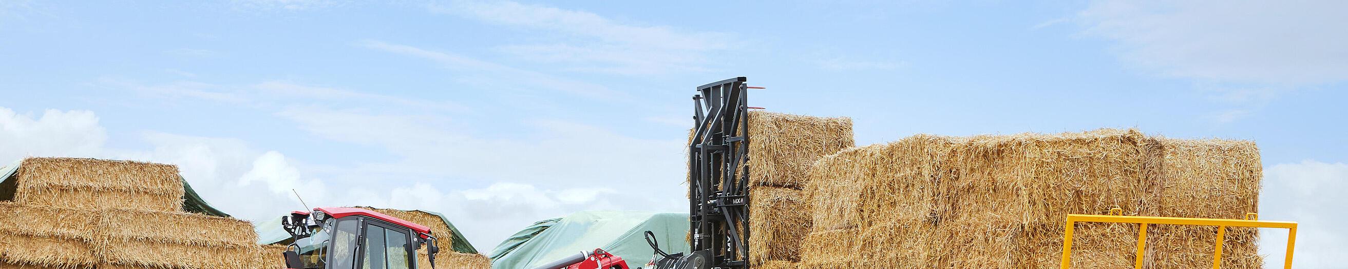 Cargadora telescópica sobre ruedas 9580T de Weidemann en acción junto a un remolque de paja